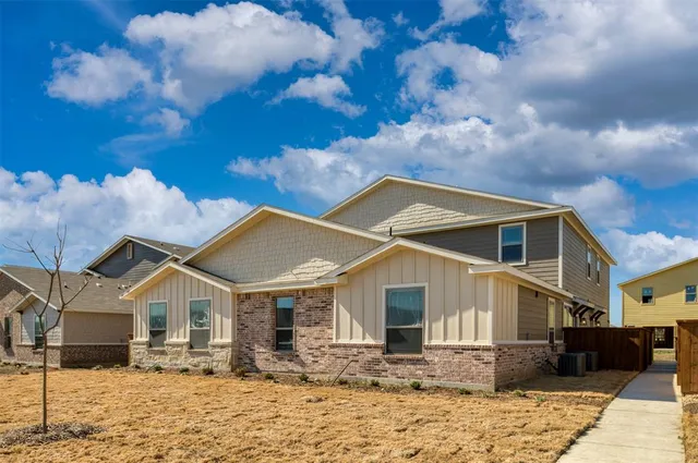 a front view of a house with a yard covered in snow