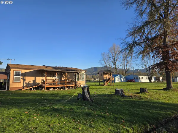 a view of a big yard with a house in the background