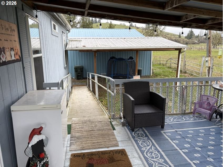 503 Old Pioneer Road Sutherlin, OR 97479 - Photo 16 of 48 a view of a patio with couches table and chairs under an umbrella with a barbeque