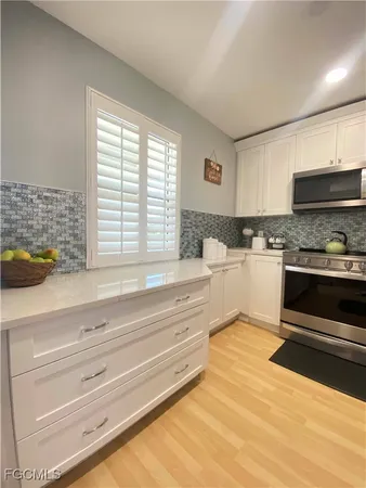 a kitchen with granite countertop white cabinets and appliances