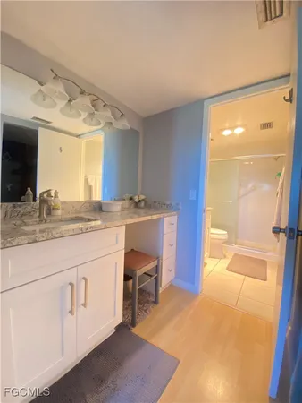 a spacious bathroom with a granite countertop sink and a mirror
