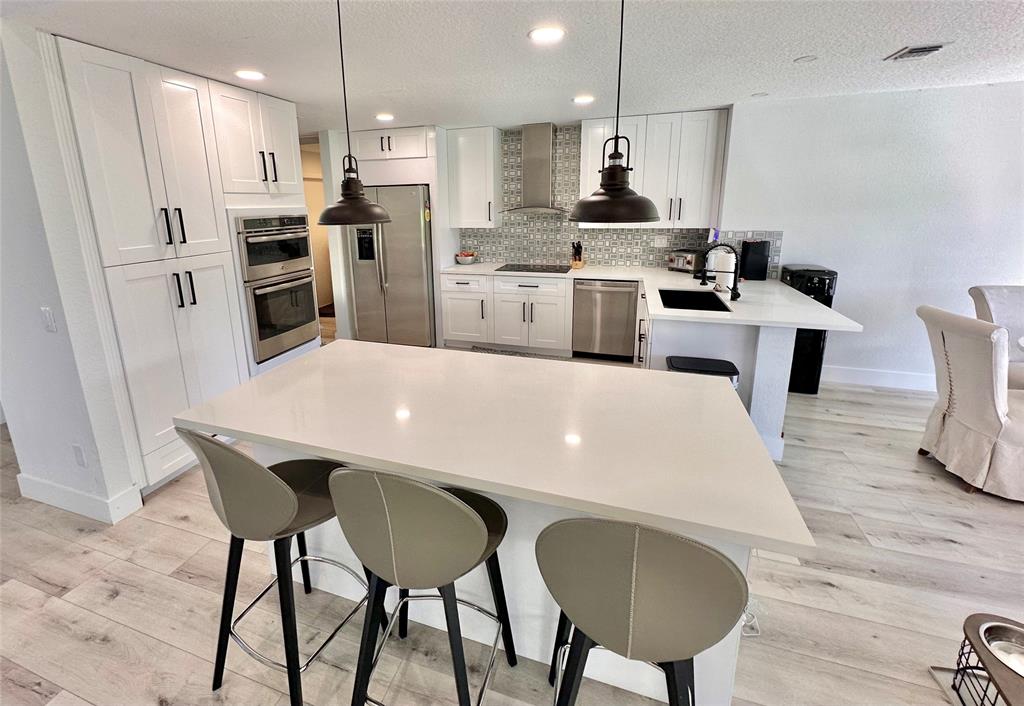 11392 Boca Woods Lane Boca Raton, FL 33428 - Photo 6 of 26 a large kitchen with a table and chairs