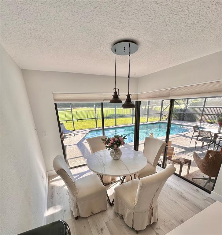 11392 Boca Woods Lane Boca Raton, FL 33428 - Photo 7 of 26 a dining room with furniture and a floor to ceiling window