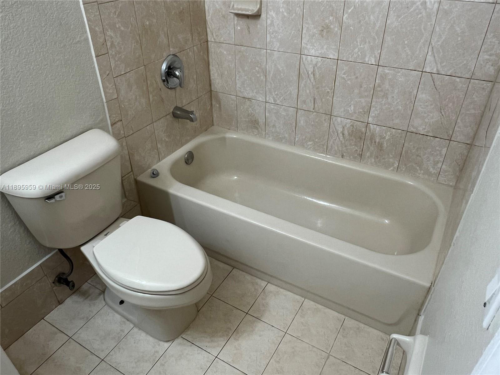 2903 Southeast 17th Avenue, Unit 201 Homestead, FL 33035 - Photo 24 of 42 a white toilet sitting next to a bathtub