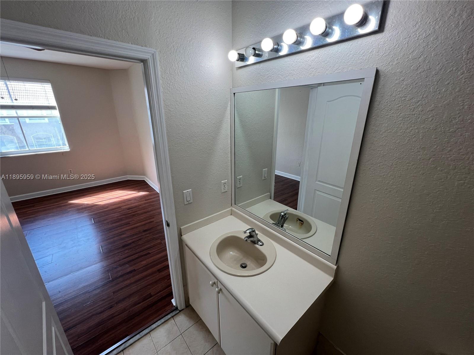 2903 Southeast 17th Avenue, Unit 201 Homestead, FL 33035 - Photo 35 of 42 a bathroom with a sink a toilet and mirror
