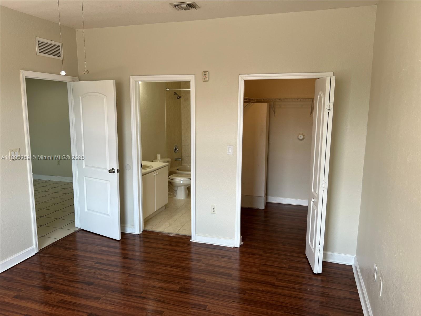 2903 Southeast 17th Avenue, Unit 201 Homestead, FL 33035 - Photo 36 of 42 a view of an empty room with wooden floor and a bathroom