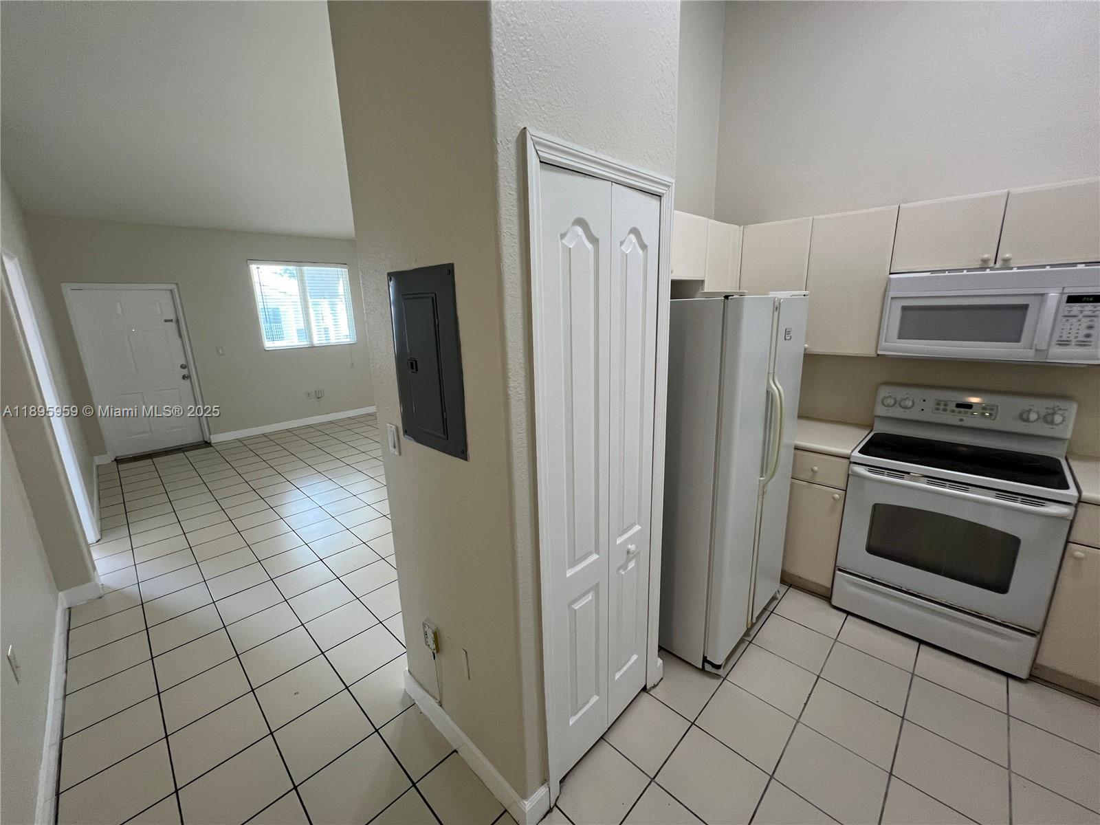 2903 Southeast 17th Avenue, Unit 201 Homestead, FL 33035 - Photo 7 of 42 a kitchen with white cabinets a refrigerator and a stove