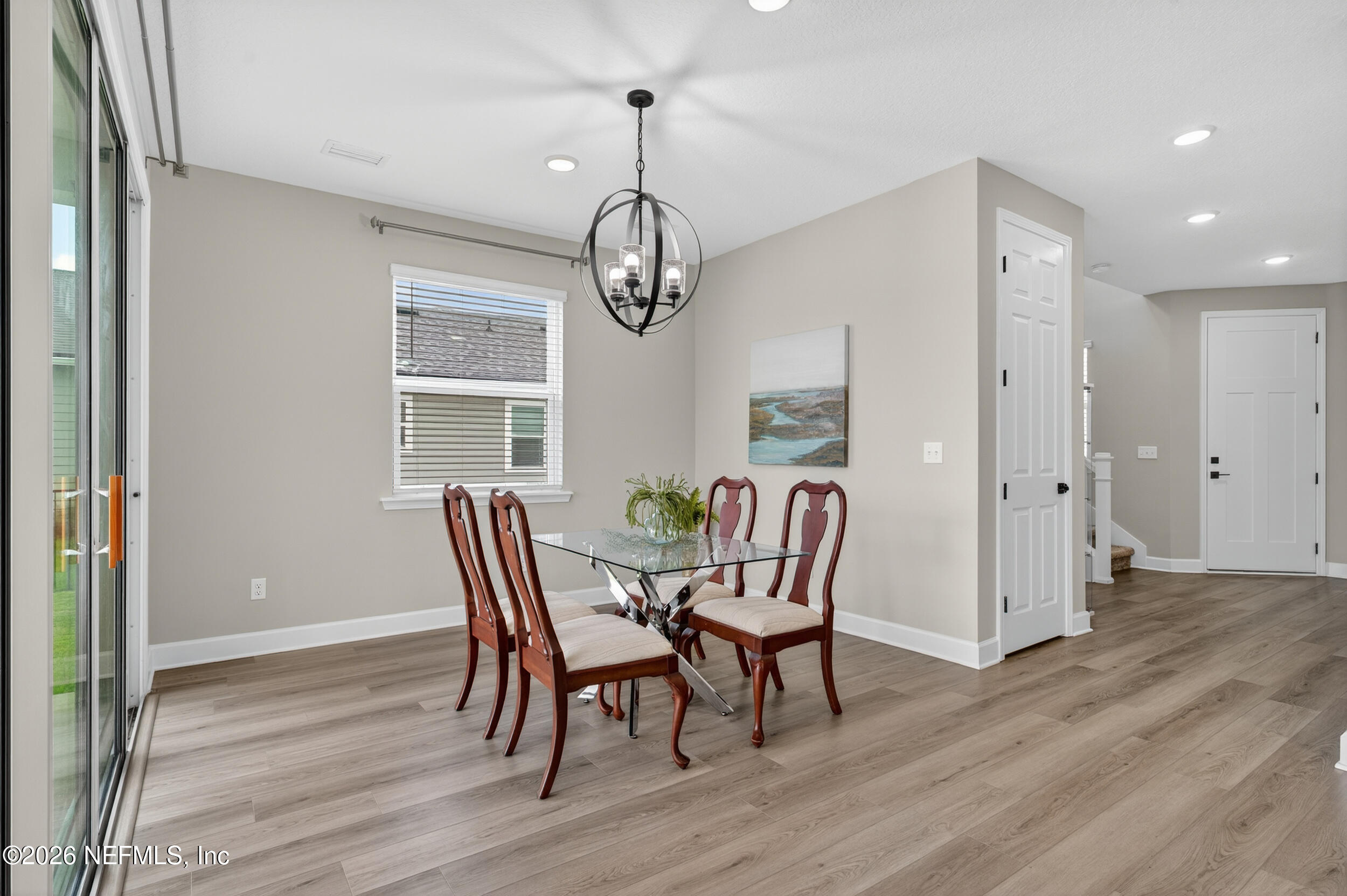 57 Cedar Elm Way St. Augustine, FL 32092 - Photo 16 of 62 a dining room with wooden floor a chandelier a glass table and chairs