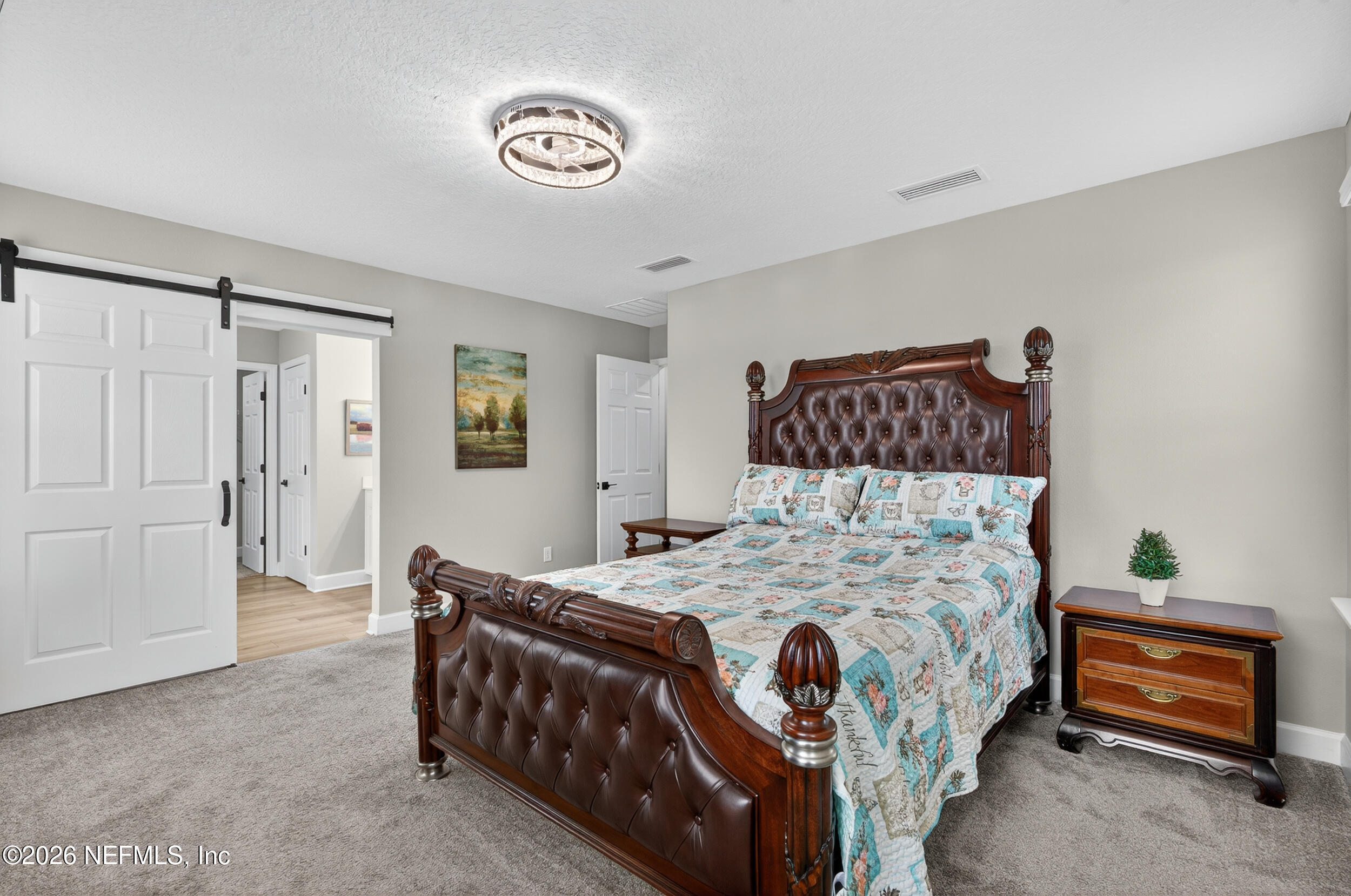 57 Cedar Elm Way St. Augustine, FL 32092 - Photo 21 of 62 a bedroom with a bed and a chandelier