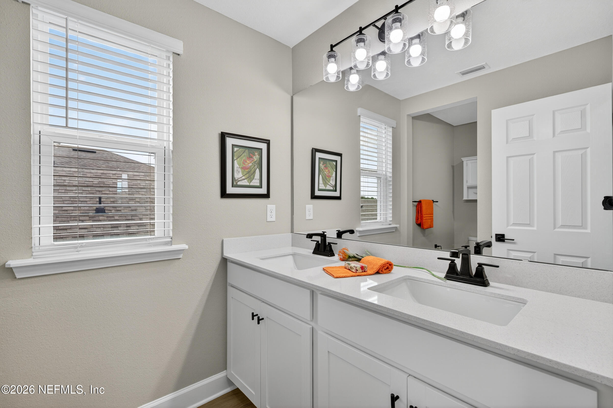 57 Cedar Elm Way St. Augustine, FL 32092 - Photo 29 of 62 a bathroom with a sink a large mirror and a window