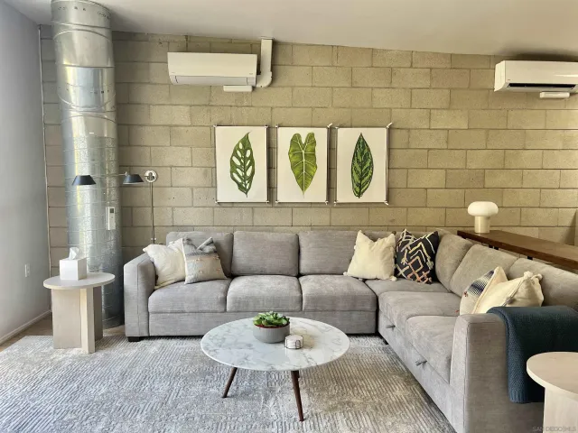 a living room with furniture and a wall painting