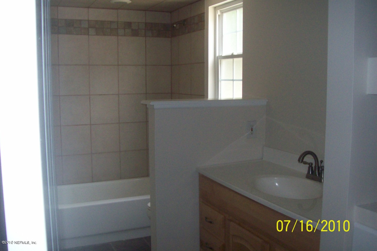 12900 Attrill Road Jacksonville, FL 32258 - Photo 4 of 7 a bath room with a sink and a bath tub