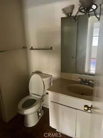 a bathroom with a granite countertop toilet sink and mirror