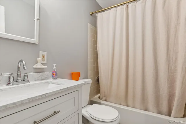 a bathroom with a sink a toilet and shower curtain