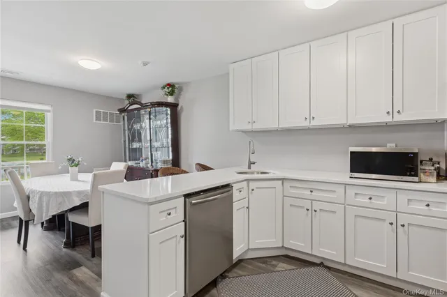a kitchen with white cabinets sink and white appliances