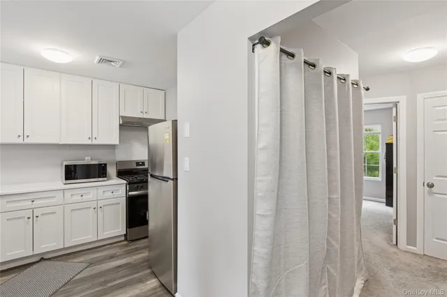 a kitchen with a refrigerator sink and cabinets