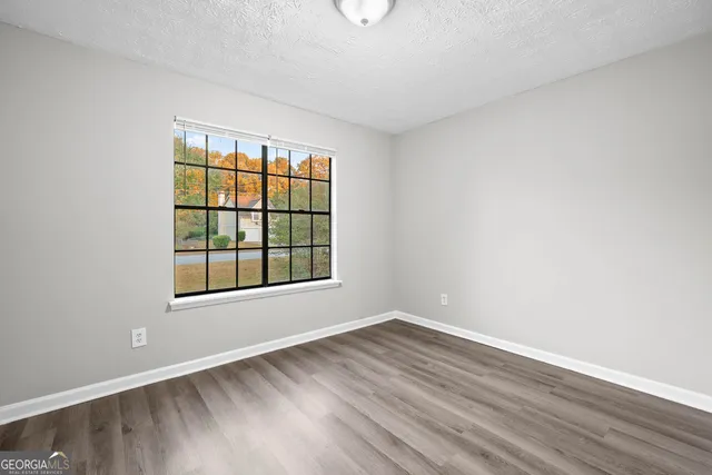 a view of an empty room with wooden floor