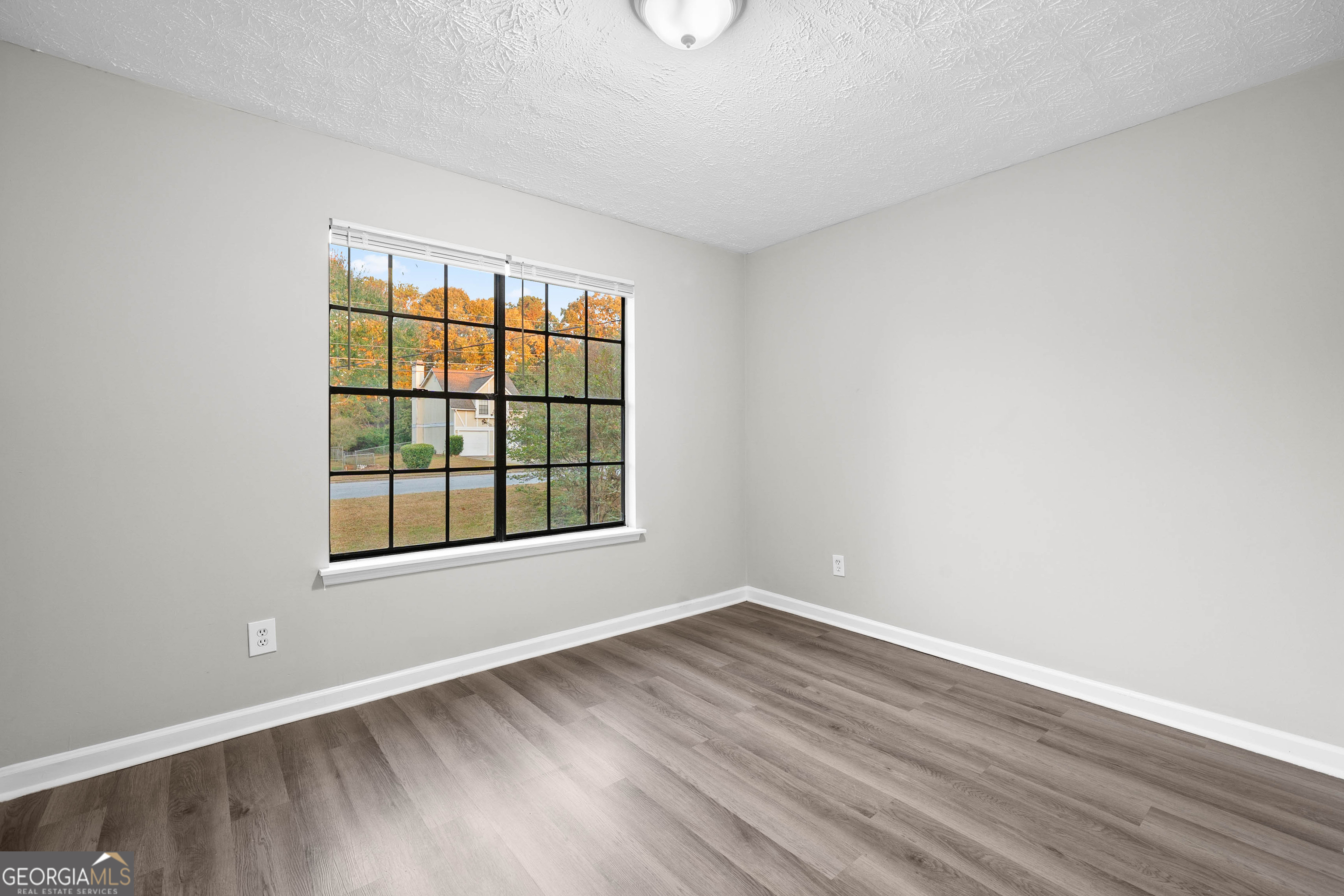 6706 Bent Creek Drive Rex, GA 30273 - Photo 11 of 27 an empty room with wooden floor and windows