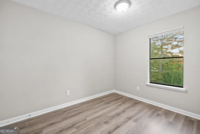 a view of an empty room with wooden floor