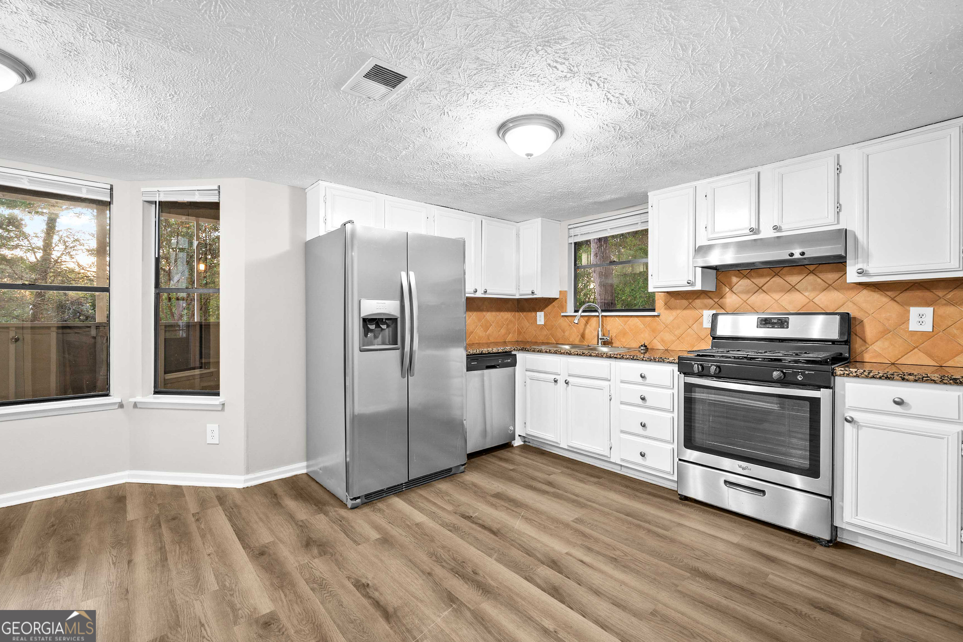 6706 Bent Creek Drive Rex, GA 30273 - Photo 3 of 27 a kitchen with granite countertop a refrigerator stove and wooden floor