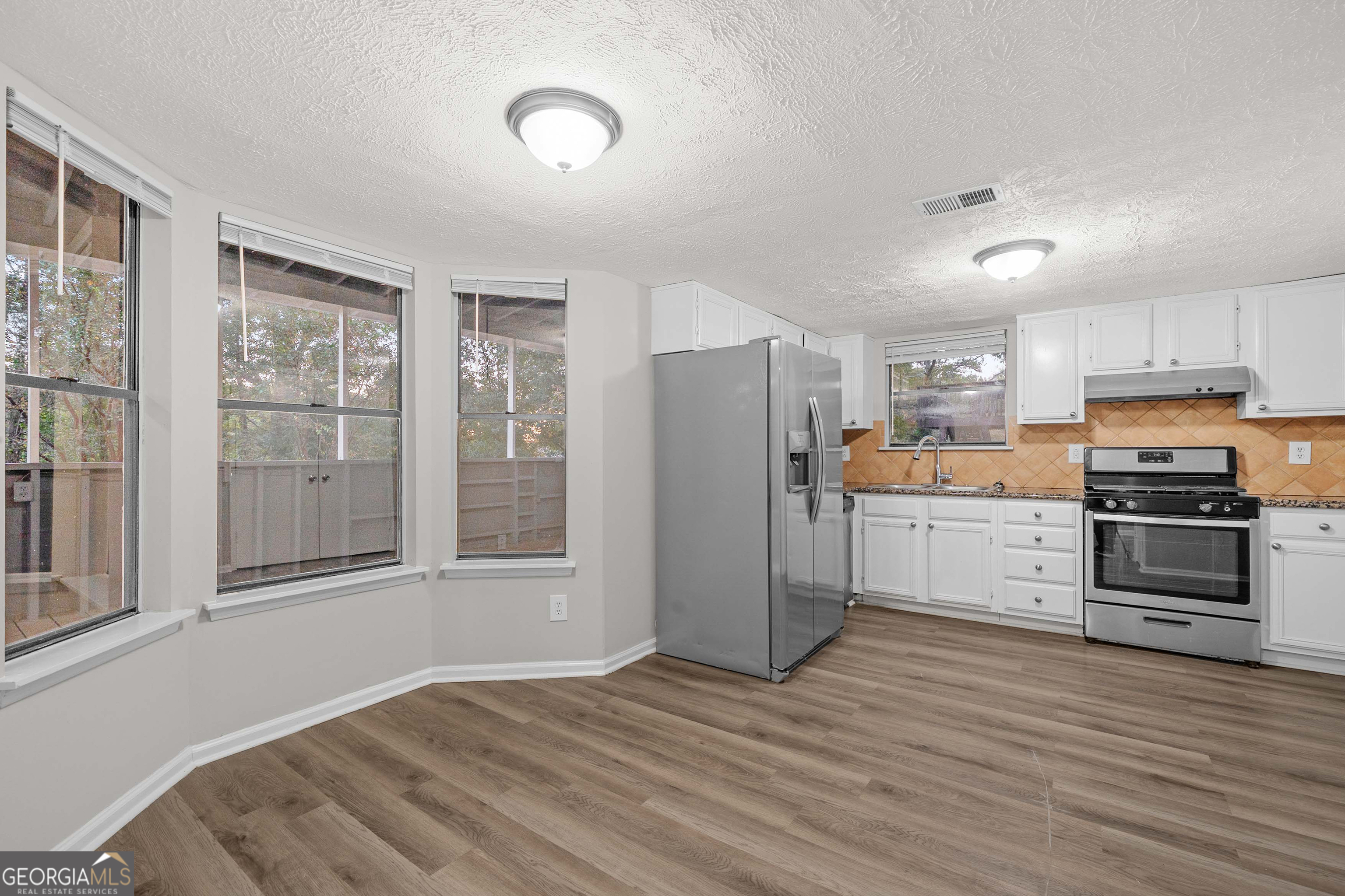 6706 Bent Creek Drive Rex, GA 30273 - Photo 4 of 27 a kitchen with stainless steel appliances wooden floor and a refrigerator