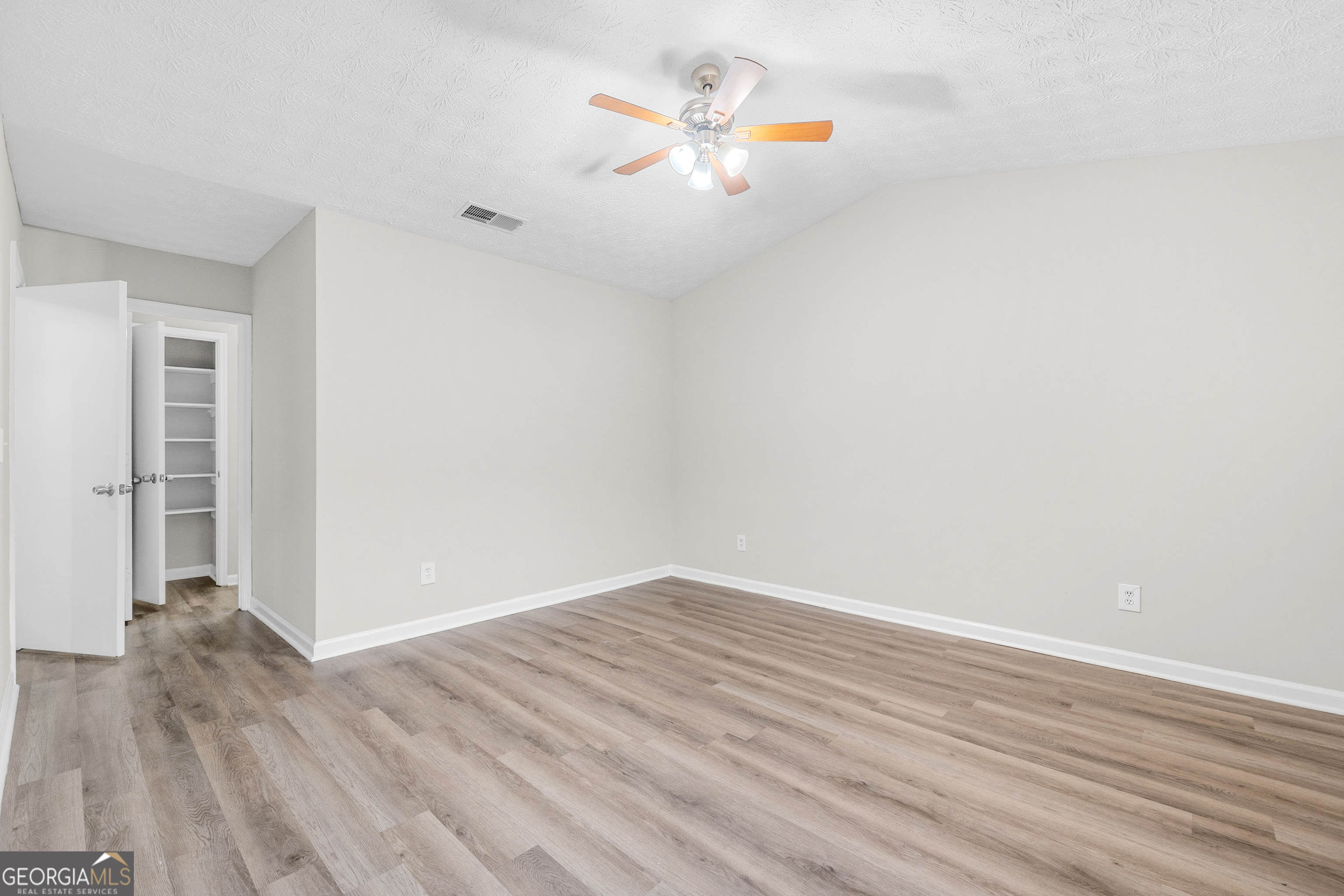 6706 Bent Creek Drive Rex, GA 30273 - Photo 8 of 27 an empty room with wooden floor and a ceiling fan