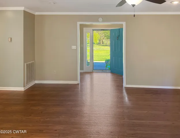 a view of a room with wooden floor and a ceiling fan