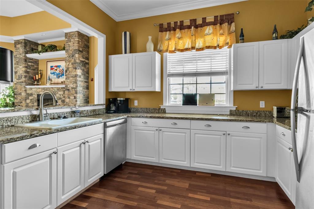 5511 Rosehill Road, Unit 203 Sarasota, FL 34233 - Photo 40 of 49 a kitchen with granite countertop white cabinets a sink and dishwasher