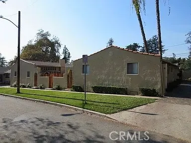 a view of a house with a yard and large tree