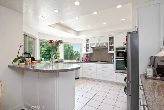 a kitchen with kitchen island granite countertop a sink and cabinets