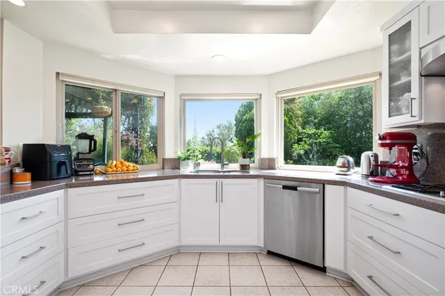 a kitchen with white cabinets and a window