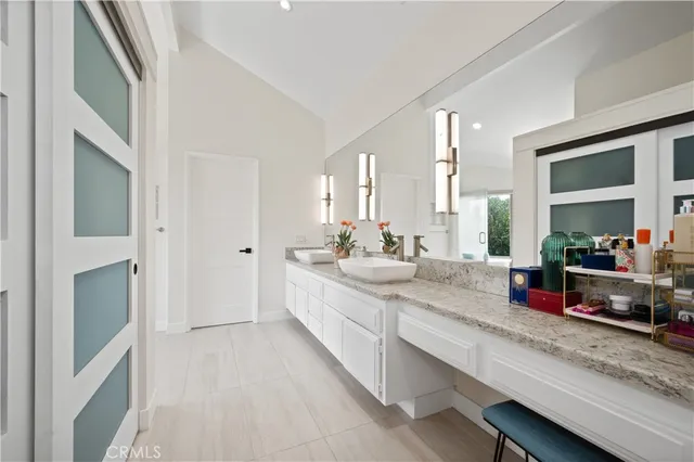 a spacious en suite bathroom with a double vanity sink and a large mirror