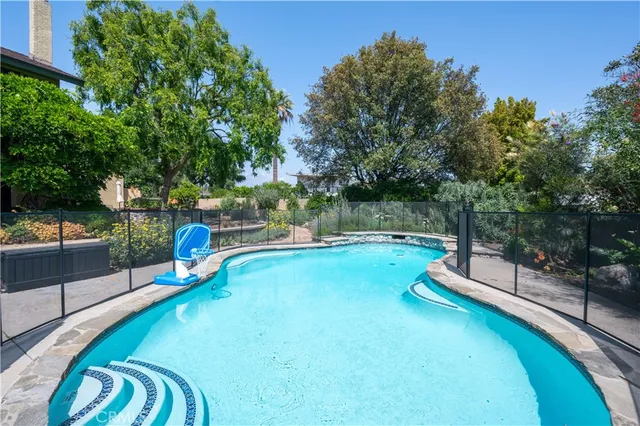 a view of a swimming pool with a patio and a backyard