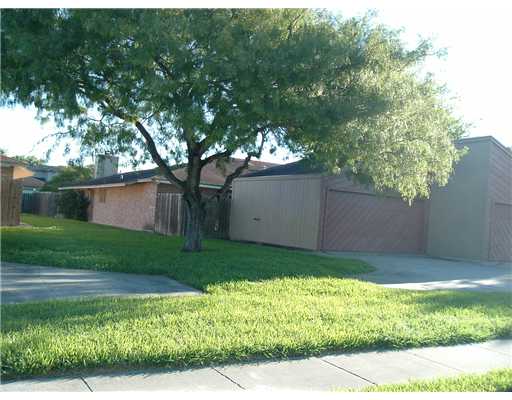 4928 Delwood Street, Unit A Corpus Christi, TX 78413 - Photo 1 of 1 a backyard of a house with plants and a large tree