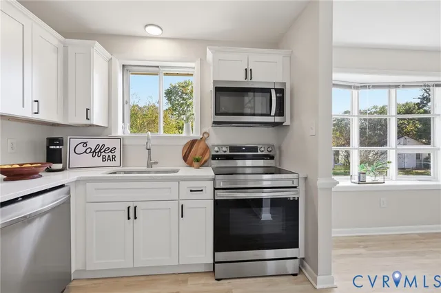 a kitchen with cabinets appliances and a window