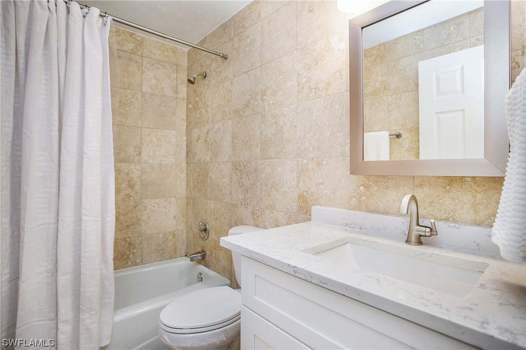 1920 Virginia Avenue, Unit 102 Fort Myers, FL 33901 - Photo 6 of 11 a bathroom with a sink a toilet and shower