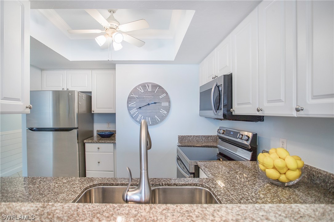 1920 Virginia Avenue, Unit 102 Fort Myers, FL 33901 - Photo 10 of 11 a kitchen with stainless steel appliances granite countertop a sink a refrigerator and a stove
