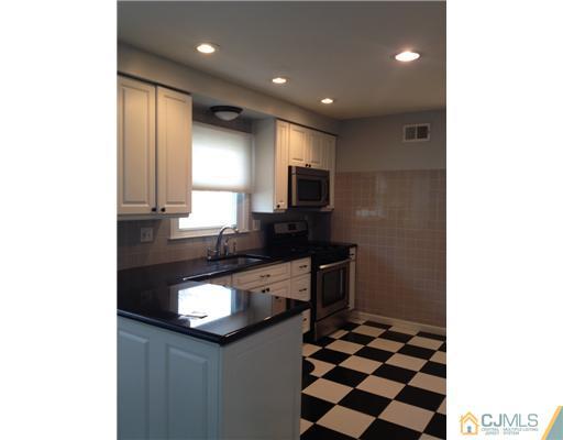 44 Brookside Road Edison, NJ 08817 - Photo 8 of 20 a kitchen with a sink a stove a microwave and cabinets