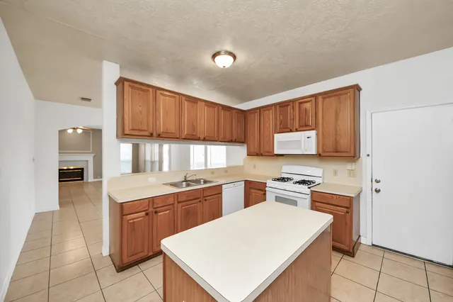 a kitchen with a sink a stove and cabinets