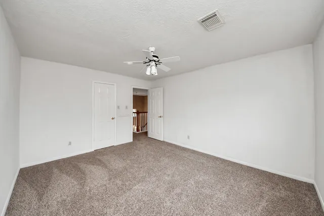 an empty room with an empty space and a ceiling fan