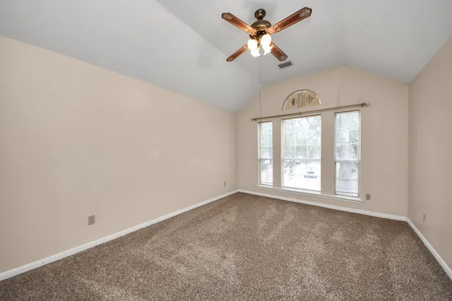 an empty room with a window and a fan