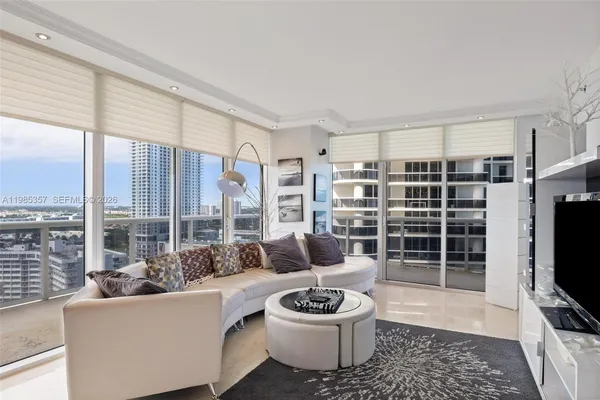 a living room with furniture a flat screen tv and a large window