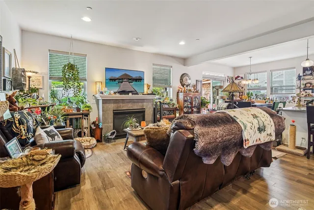 a bed room with a bed a couches a flat screen tv and a fireplace