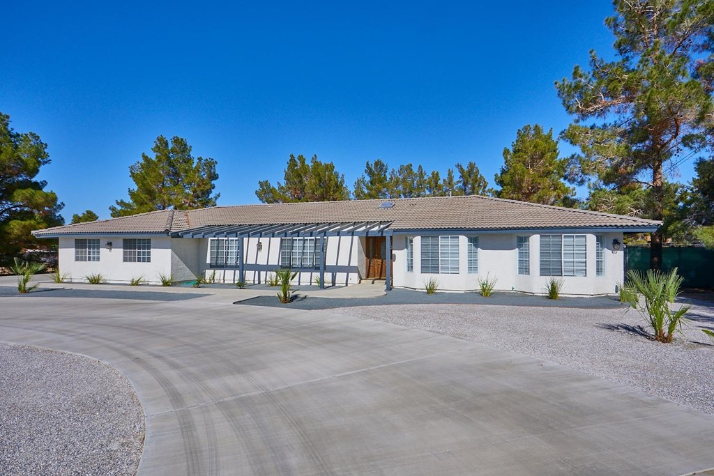 18980 Red Feather Road Apple Valley, CA 92307 - Photo 1 of 1 a front view of a house with a garden