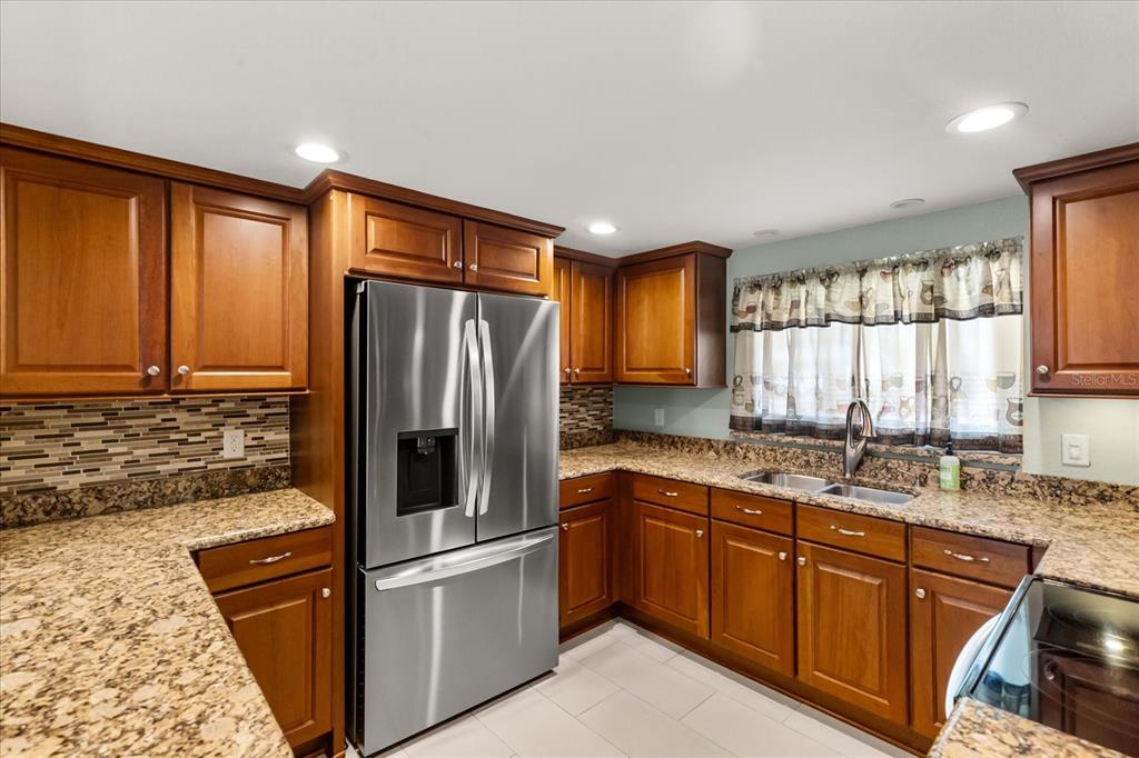 620 Jacaranda Street Dunedin, FL 34698 - Photo 8 of 30 a kitchen with stainless steel appliances granite countertop a refrigerator sink and cabinets