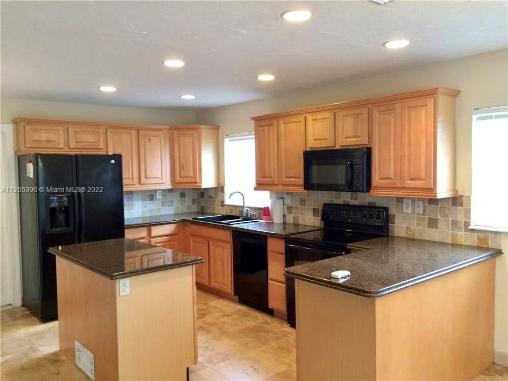 Welleby Sunrise, FL 33351 - Photo 3 of 15 a kitchen with stainless steel appliances granite countertop a refrigerator stove microwave sink and cabinets