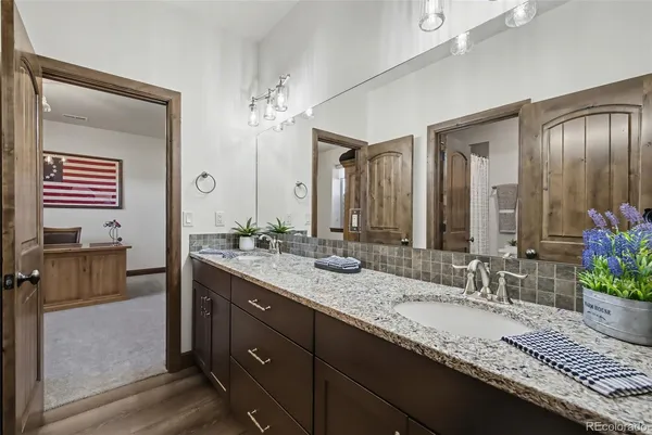 a bathroom with a granite countertop sink and a mirror