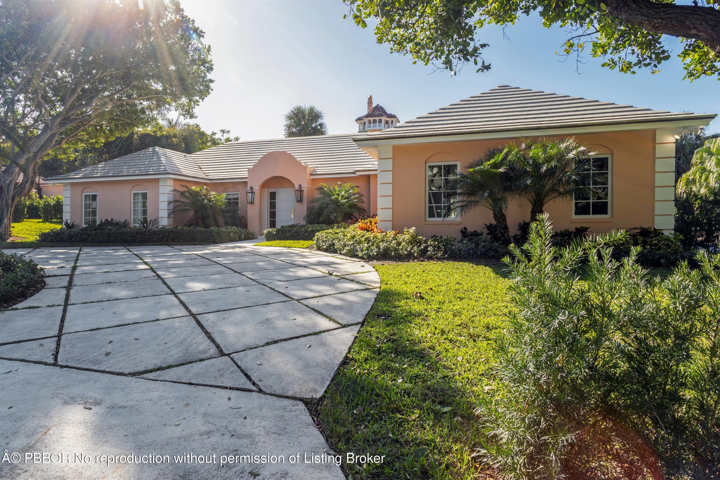 124 Woodbridge Road Palm Beach, FL 33480 - Photo 3 of 44 a front view of a house with a yard and garage