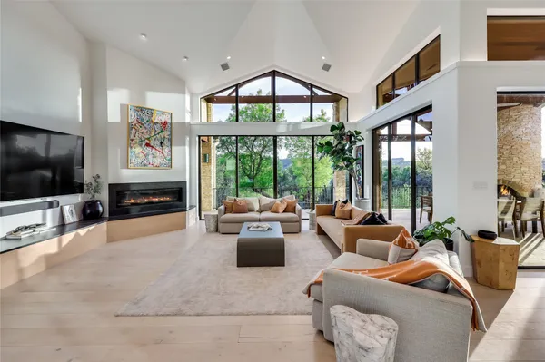a living room with furniture a large window and a flat screen tv