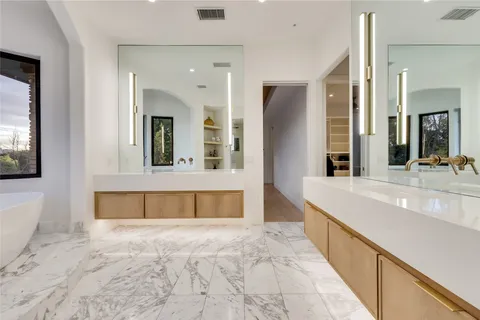 a bathroom with a tub sink and mirror